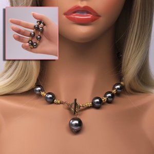 Dark pearl necklace with toggle lock and matching bracelet.